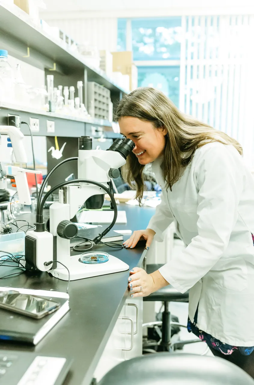 Woman looking through microscope - Axolotl Biosciences - 2