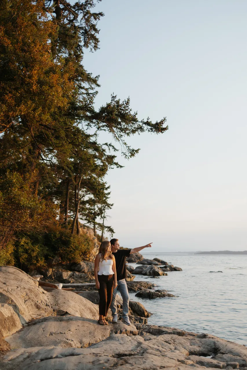 Couple enjoying a peaceful oceanfront evening view pointing in distance
