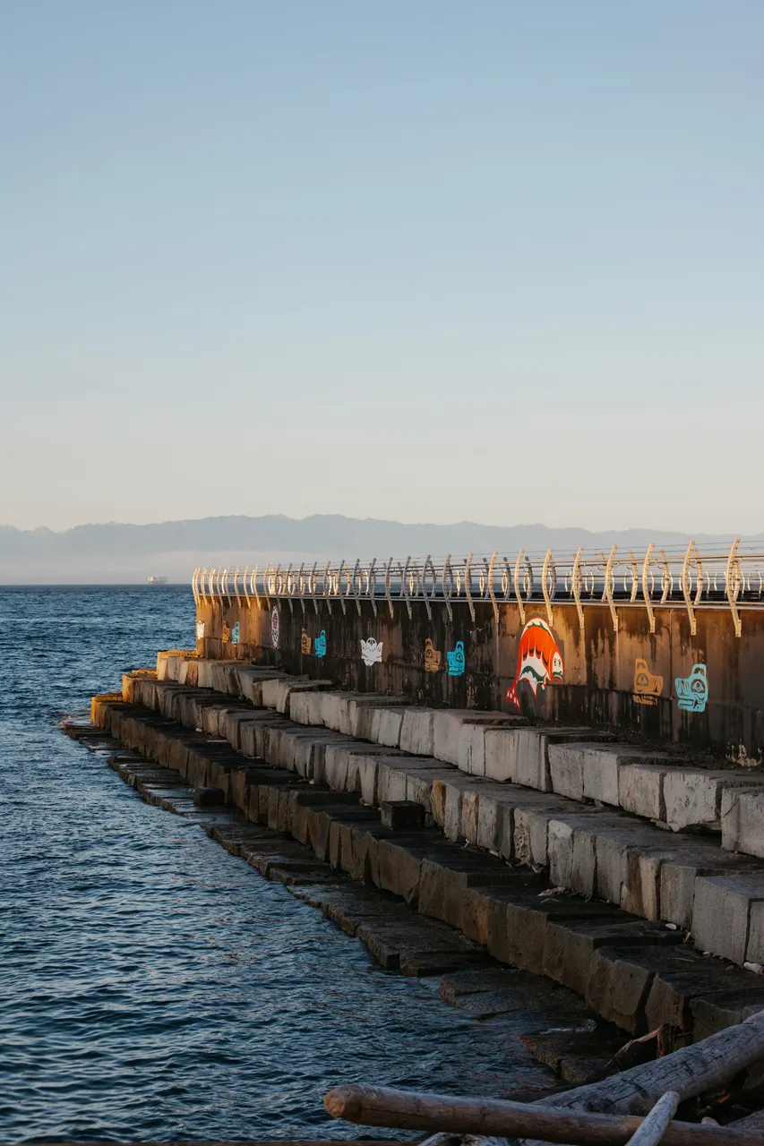 Mural-lined seawall under a clear evening sky