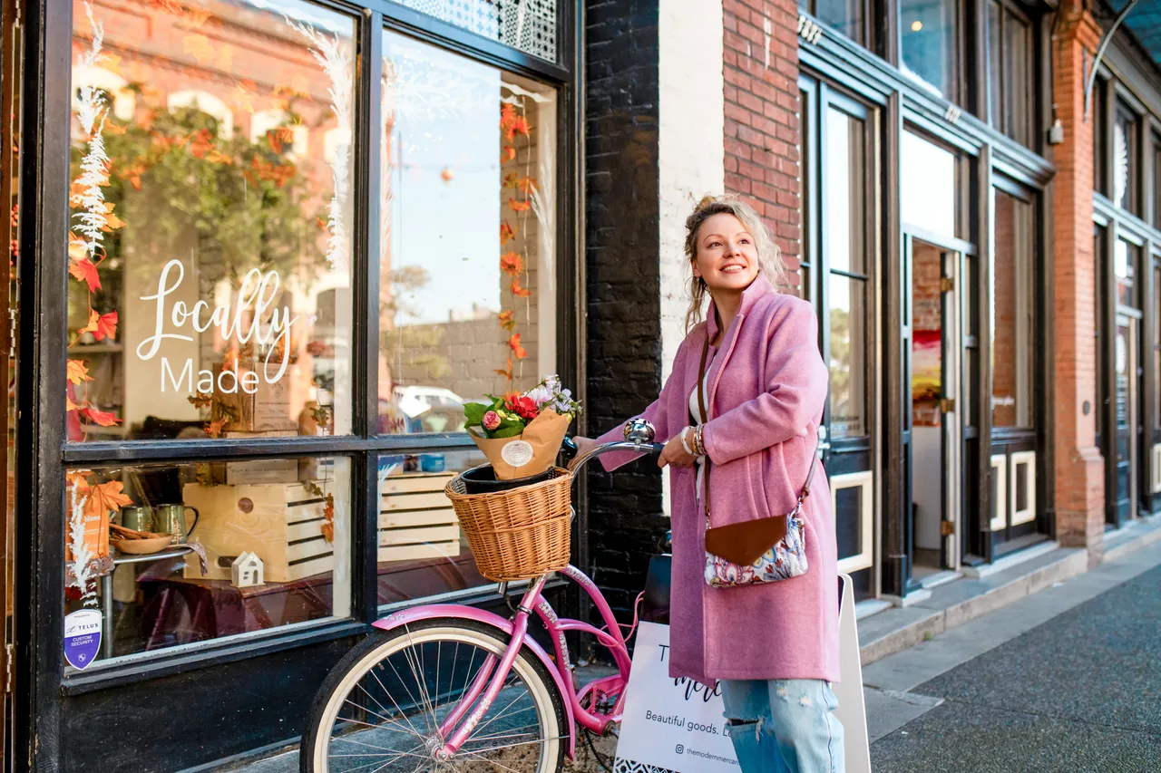 Woman with bike by storefront - Victoria
