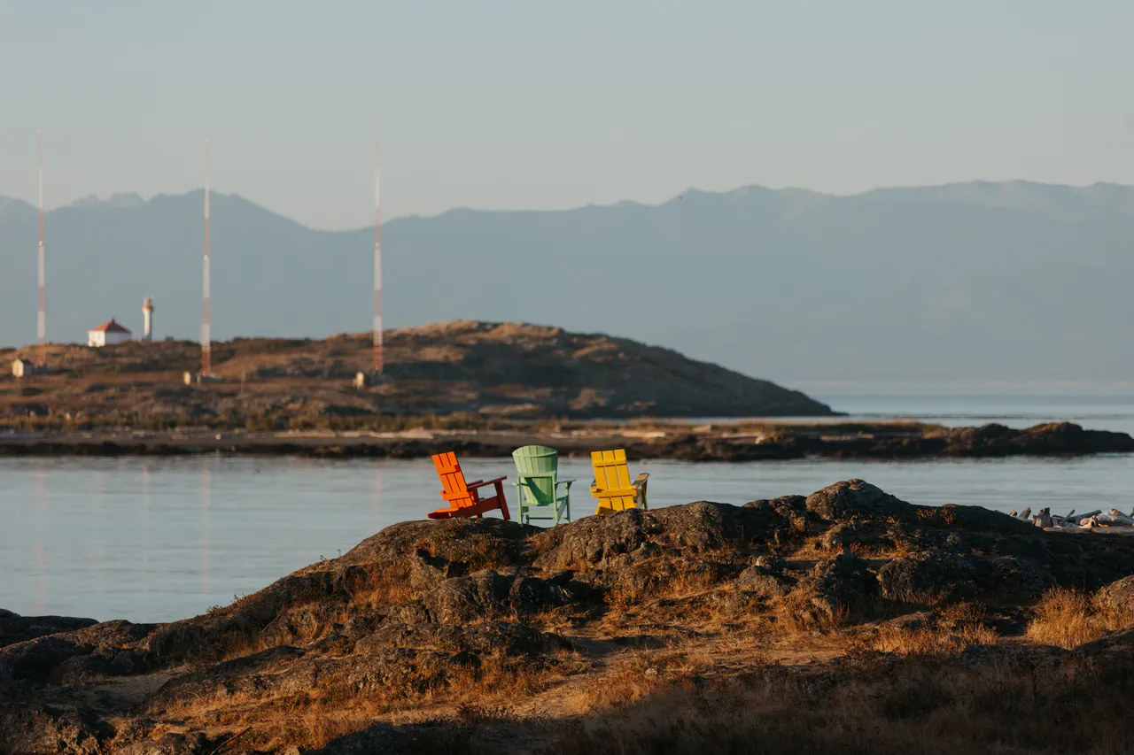 Peaceful morning by the rocky coastal shoreline with mountains in the background