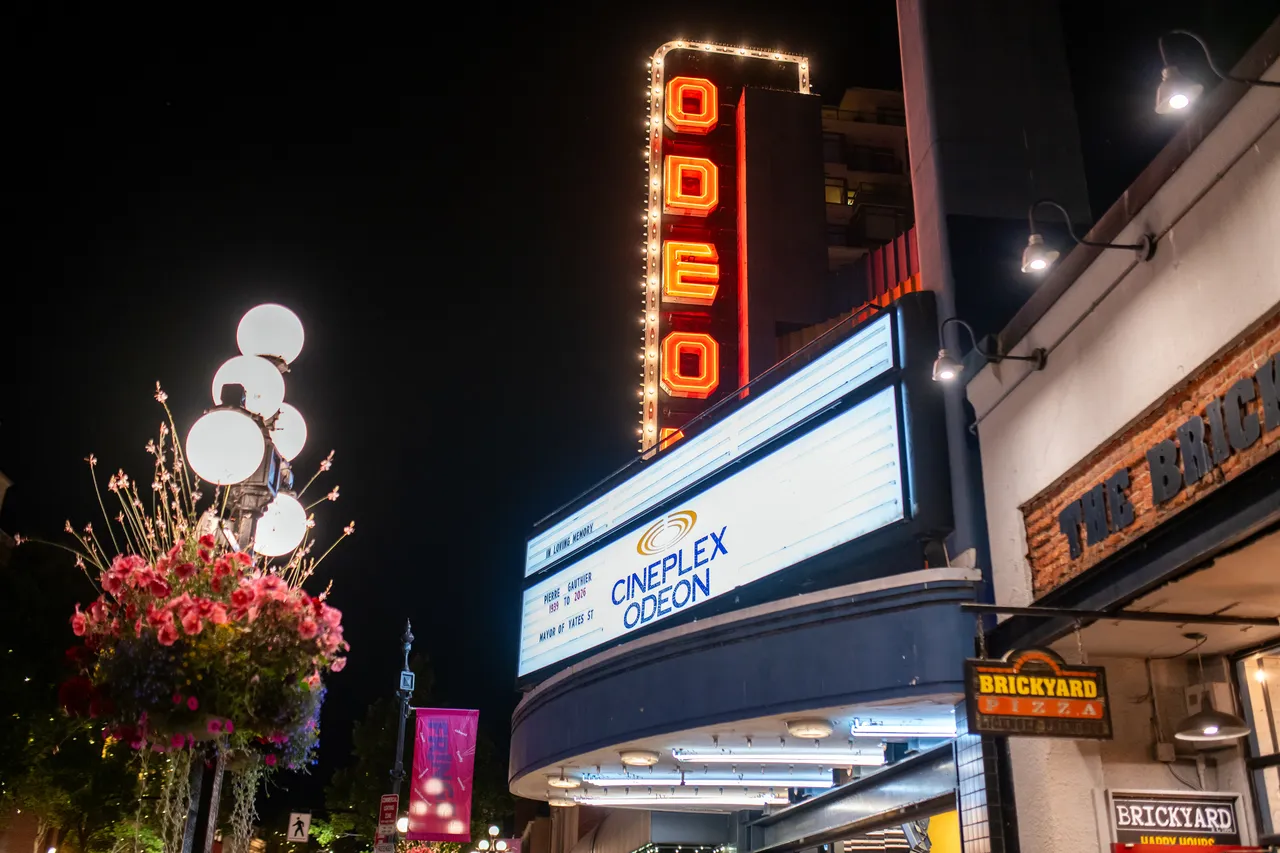Vintage theatre marquee lit up at night above a downtown sidewalk