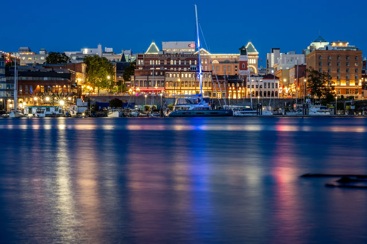 Boats on Harbour with City Buildings in Background at Night
