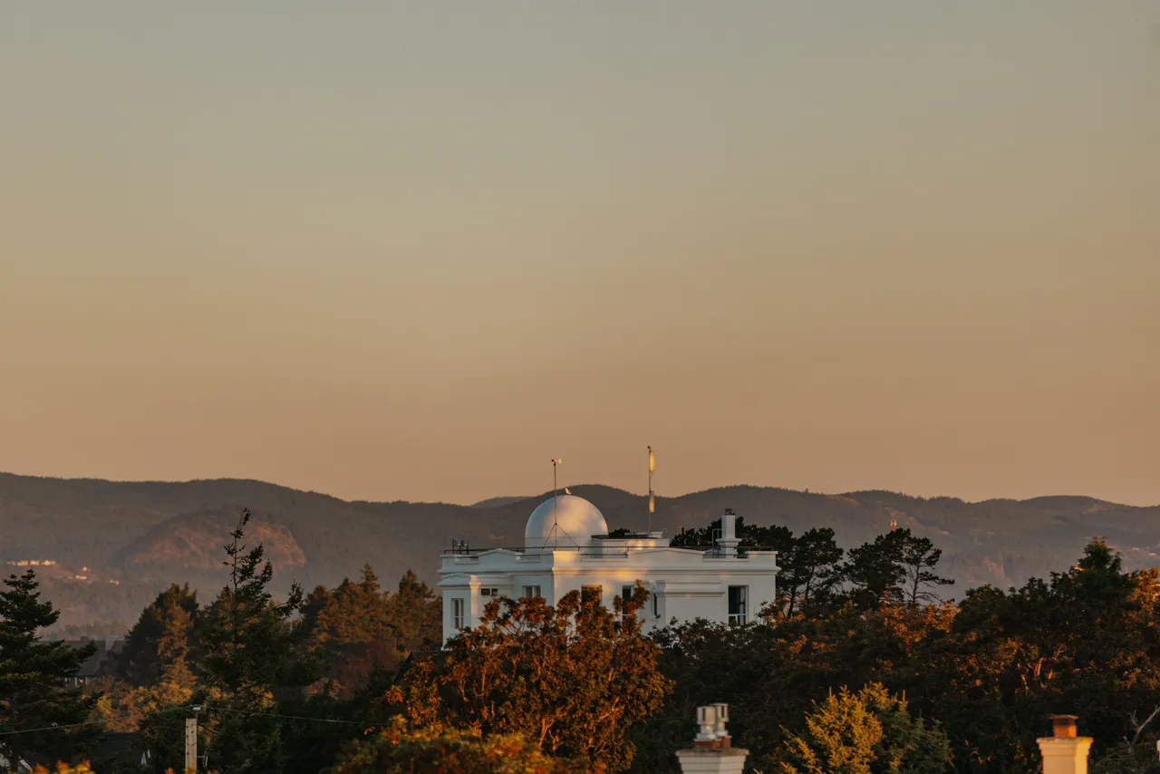 Hilltop dome bathed in warm light with mountains in background