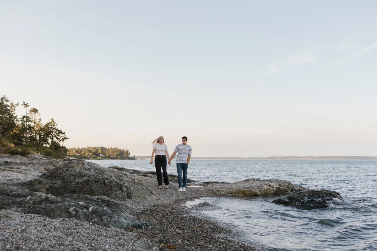 Couple walking along a quiet coastal shoreline