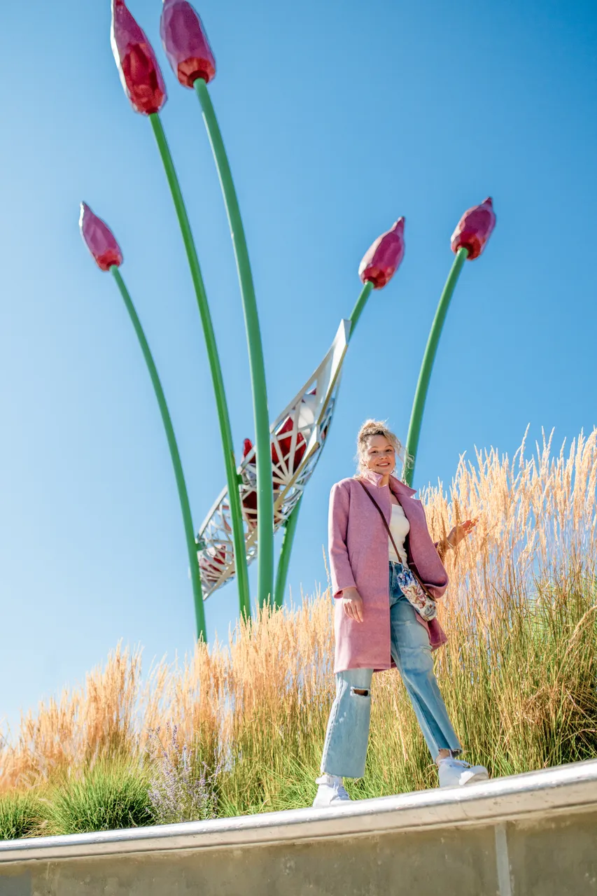 Woman walking next to tulip sculpture - 2 - Victoria
