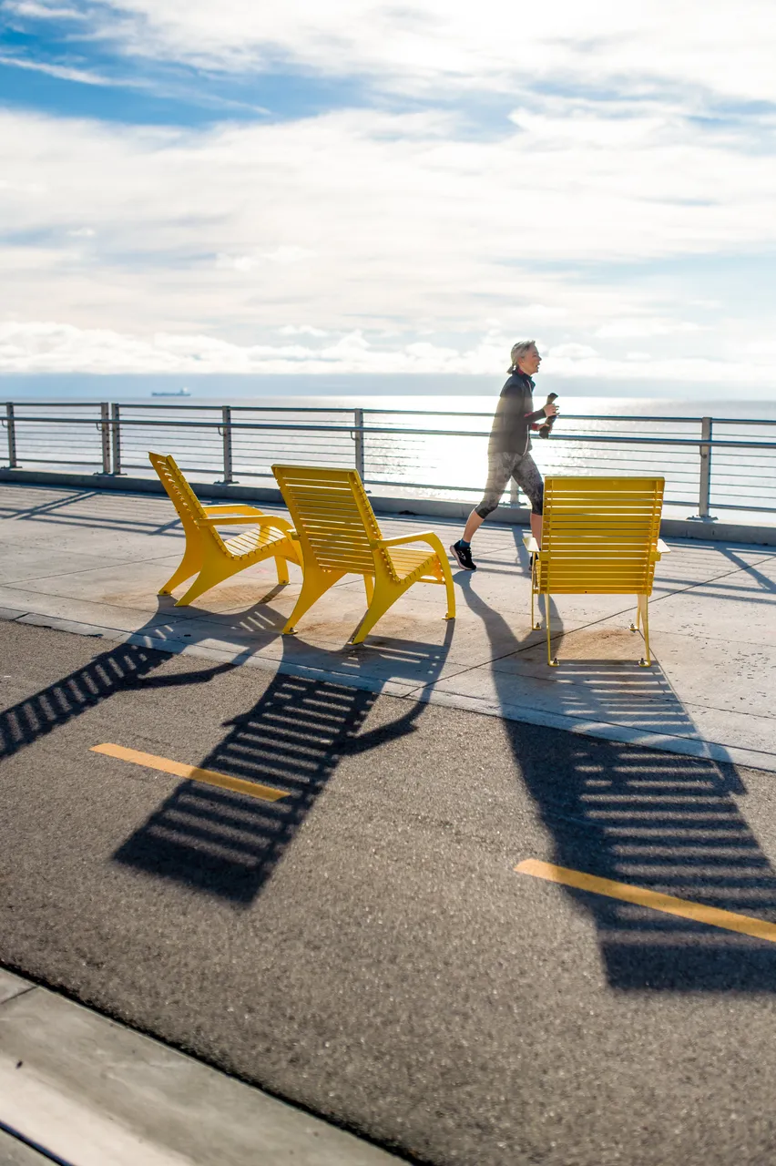 Woman running by lounge chairs