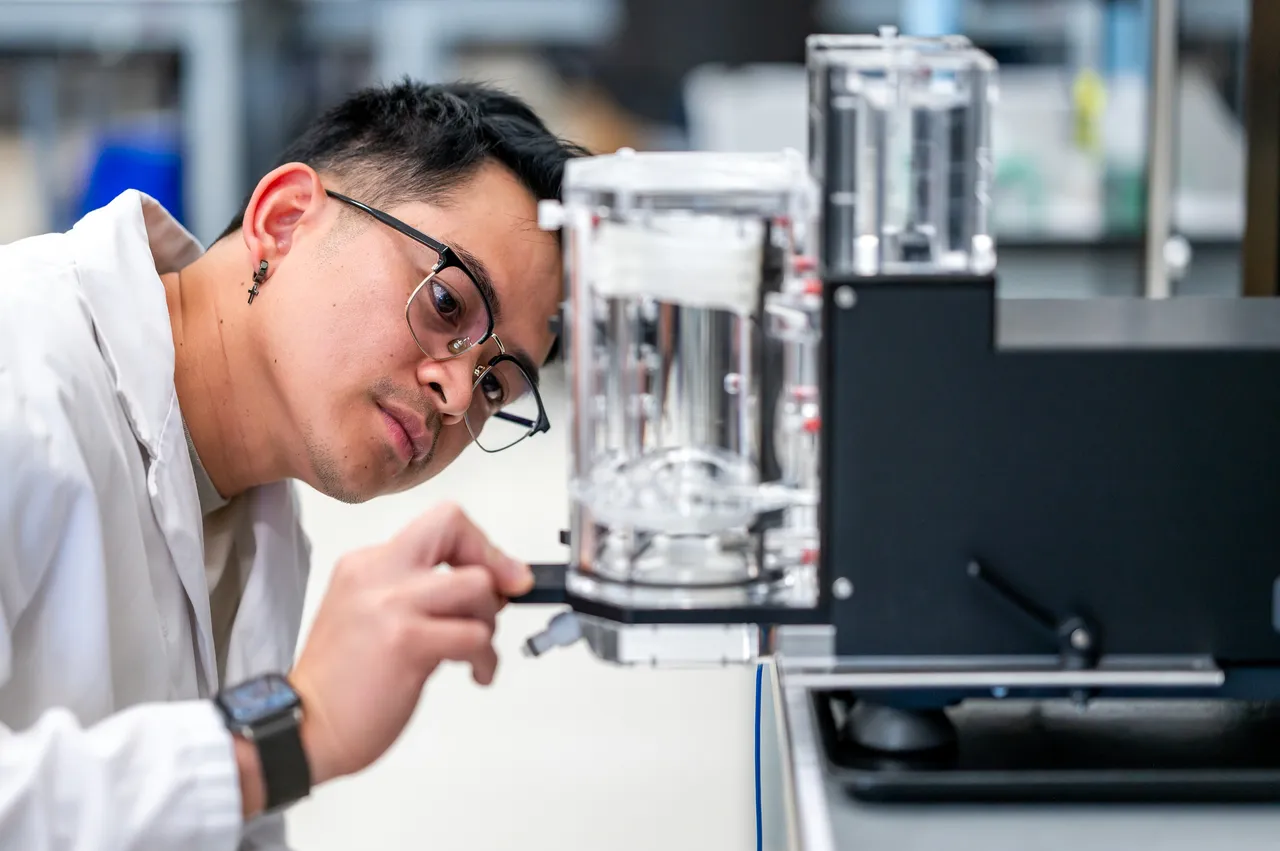 Person in Labcoat at Medical Manufacturing Company Looking at Glass